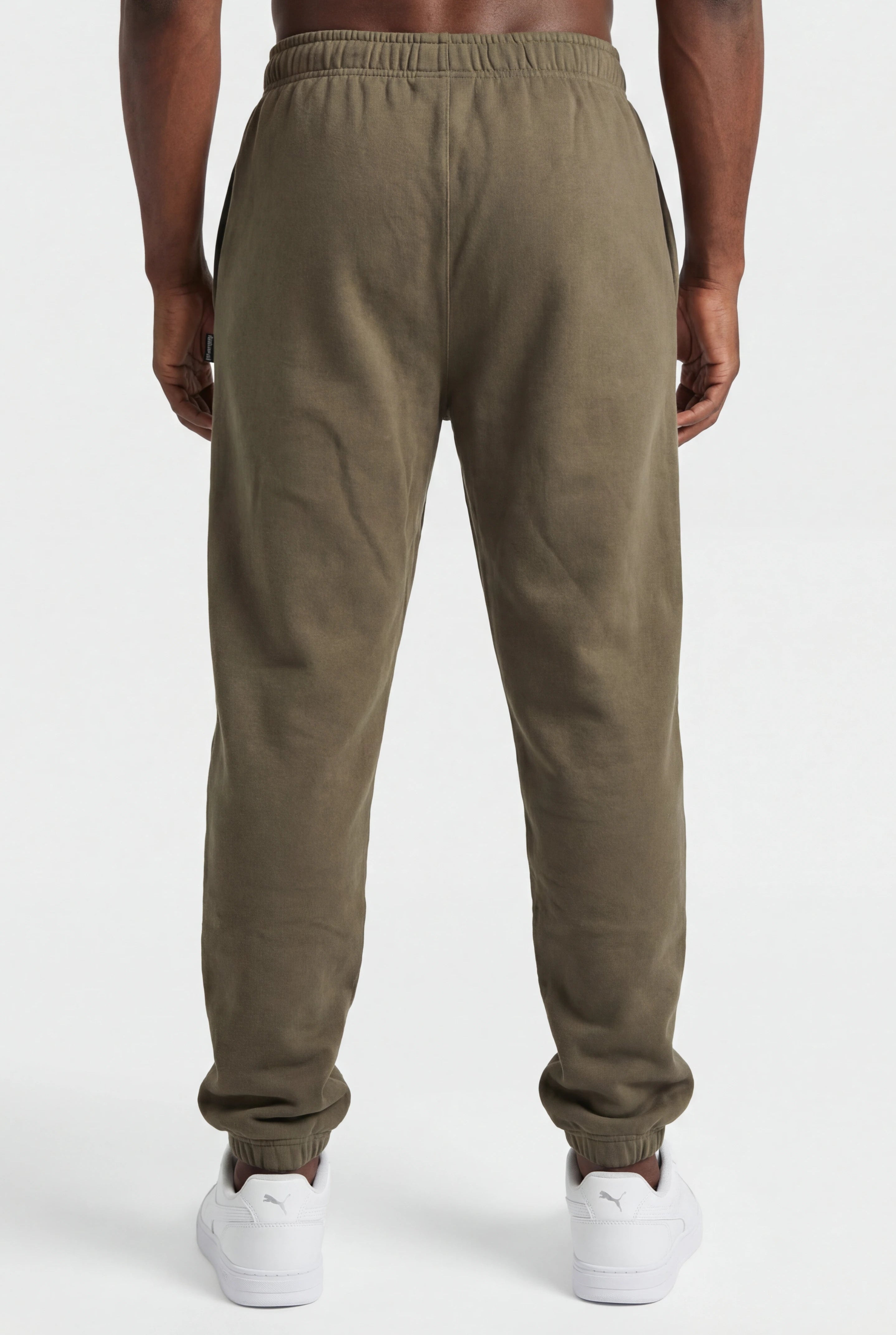Person wearing olive green sweatpants on a white background
