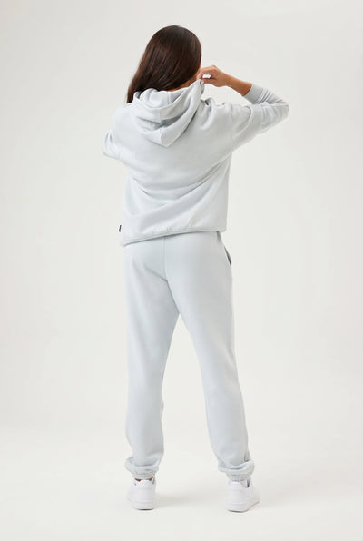 Person wearing a light blue hoodie and pants on a white background