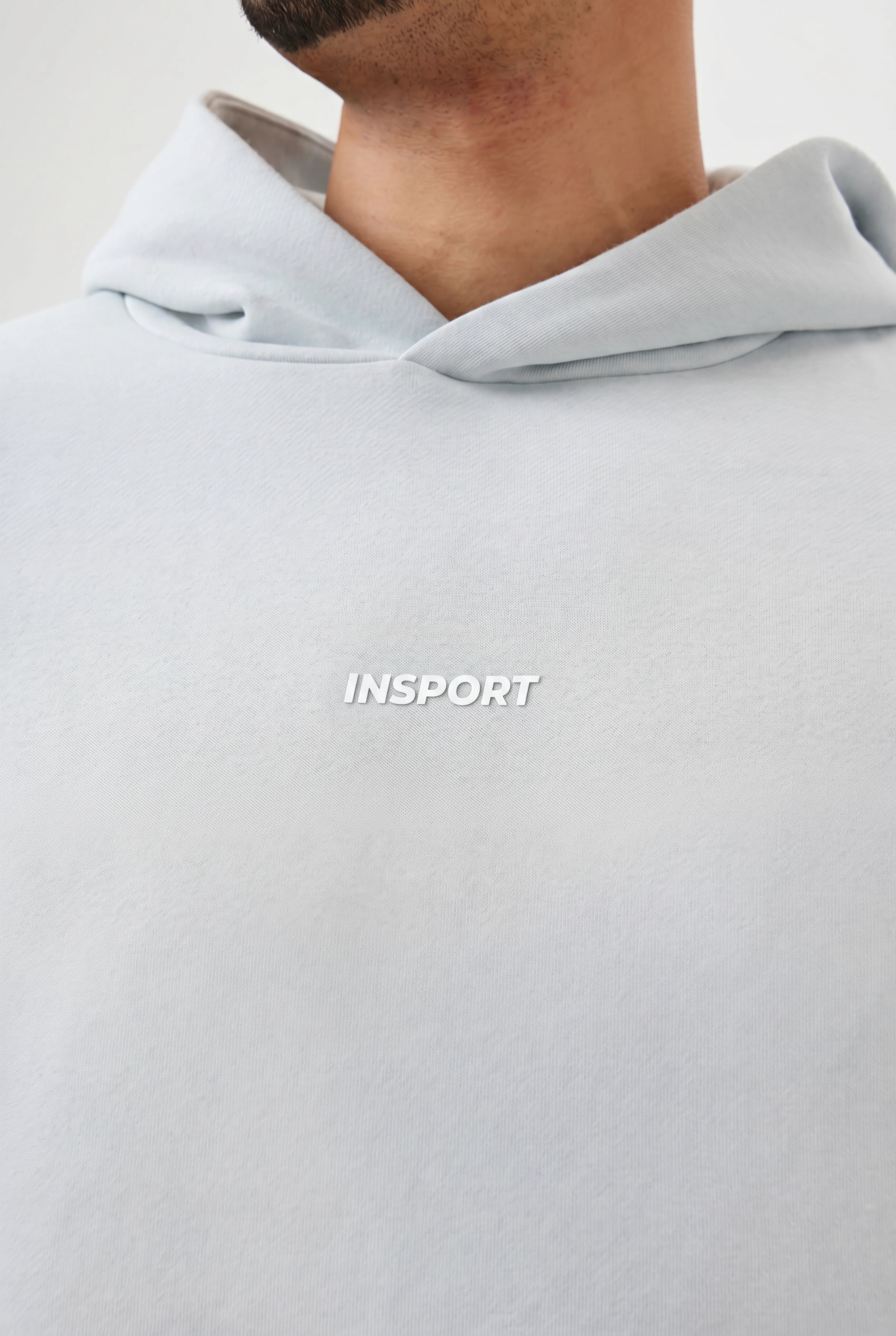 Light blue hoodie with 'INSPORT' logo on a white background