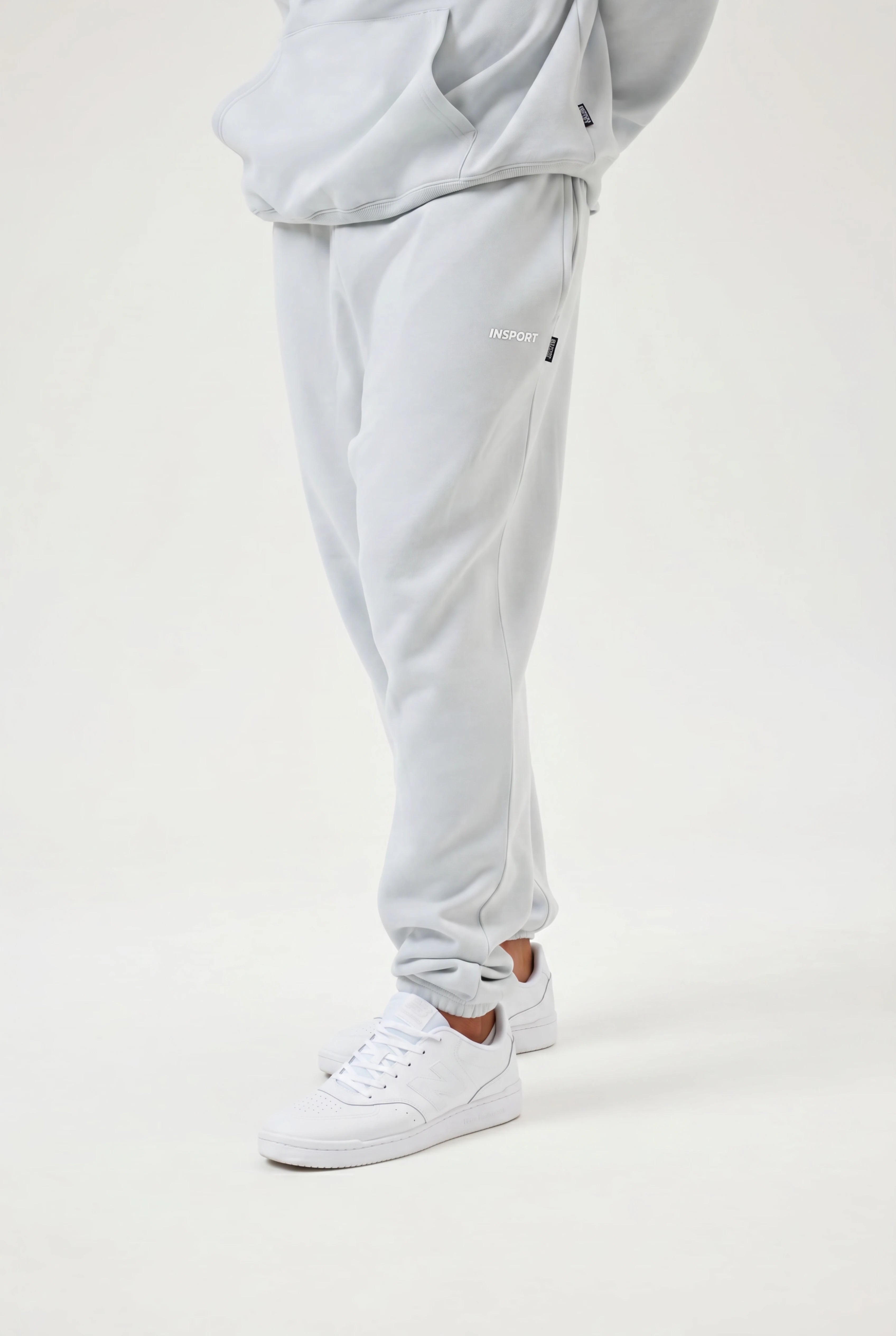Light blue sweatpants worn by a person on a white background