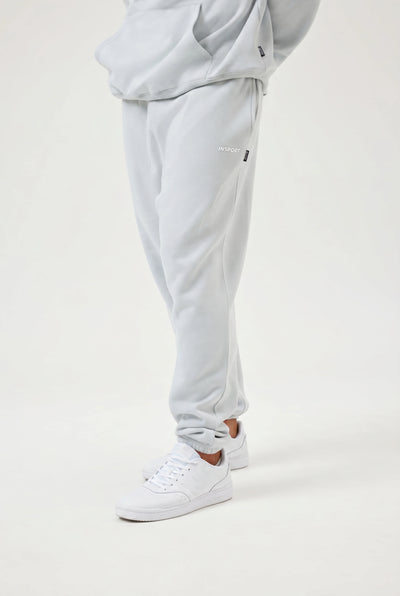 Light blue sweatpants worn by a person on a white background