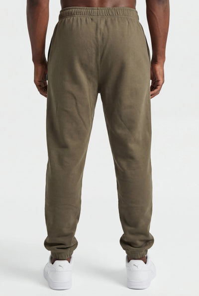 Person wearing olive green sweatpants on a white background